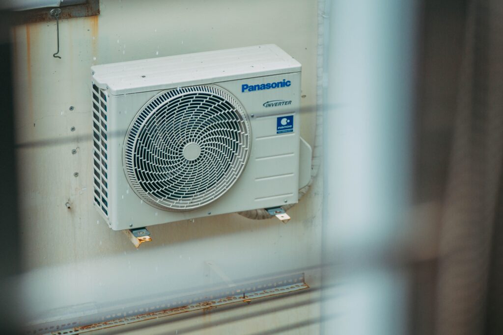 pexels-photo-27134985-27134985 Air conditioner unit mounted outdoors on a building wall, showcasing modern HVAC technology.