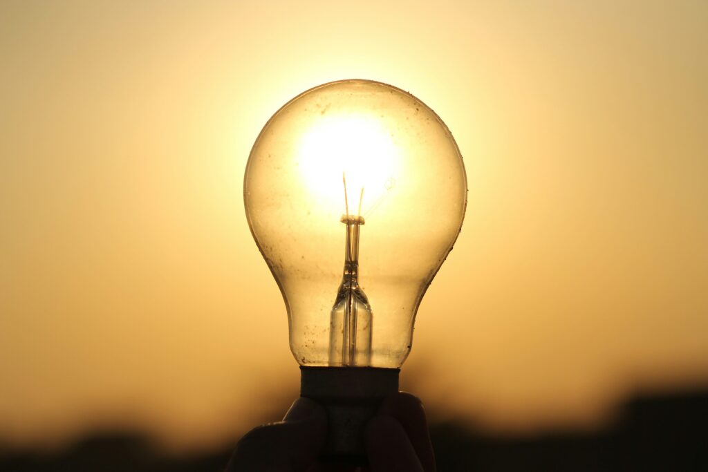 pexels-photo-28214102-28214102 A light bulb held against a golden sunset in Lahore, symbolizing energy and innovation.
